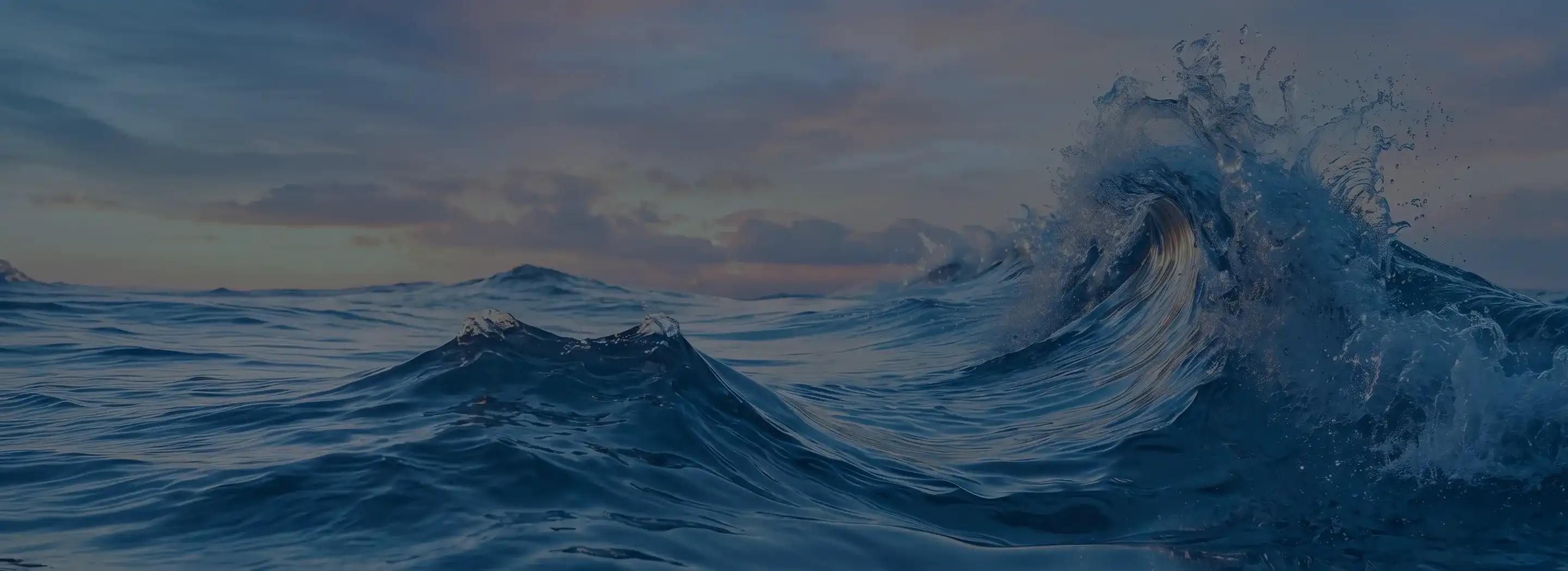 Dark blue ocean waves curling and breaking under a dusky evening sky